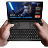 GPD WIN Mini 2024: Výkonný prenosný herný počítač so 7" FHD 120Hz VRR displejom. Je vybavený procesorom AMD Ryzen 7 8840U, 32 GB RAM, 2 TB úložiskom NVMe. Clamshell dizajn kombinuje plnohodnotnú QWERTY klávesnicu s hernými ovládacími prvkami vrátane dvoch joystickov a tlačidiel. Kompaktný tvar sa pohodlne drží v rukách. Obrazovka zobrazuje hernú postavu so svietiacim mečom a predvádza živú grafiku. Viditeľné špecifikácie: 7" obrazovka, 120 Hz VRR, Ryzen 7 8840U, 32 GB RAM, 2 TB úložisko. Zdôraznené "HANDHELD PC - CLAMSHELL". Prítomné logá AMD Ryzen a Radeon. Zariadenie ponúka prenosné hranie a produktivitu v jednom, čím preklenuje medzeru medzi vreckovou konzolou a mini notebookom.
