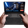 GPD WIN Mini 2024: Powerful handheld gaming PC with 7" FHD 120Hz VRR display. Features AMD Ryzen 7 8840U, 32GB RAM, 1TB NVMe storage. Clamshell design combines full QWERTY keyboard with gaming controls, including dual joysticks and buttons. Compact form factor held comfortably in hands. Screen displays game character with glowing sword, showcasing vibrant graphics. Specs visible: 7" screen, 120Hz VRR, Ryzen 7 8840U, 32GB RAM, 1TB storage. "HANDHELD PC - CLAMSHELL" emphasized. AMD Ryzen and Radeon logos present. Device offers portable gaming and productivity in one, bridging gap between handheld console and mini laptop.