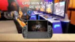 Pilt GPD WIN 4 2025 mudelist, mis tutvustab selle kompaktset füüsilise klaviatuuri ja integreeritud mängukontrolliga pihuarvutit. Seade on kujutatud esiplaanil puupinnal, taustal on hägune mängude seadeldis, millel on mitu monitori ja mängutoolid. Tekst "GPD WIN 4 2025 REVIEW" on nähtavalt pildi ülaosas.