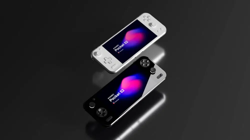 To AYANEO Pocket S2 håndholdte spillkonsoller, en hvit og en svart, er vist svevende eller vinklet mot en grå bakgrunn. Den hvite konsollen er øverst, litt til venstre, og viser "AYANEO Pocket S2" på skjermen med en fargerik, abstrakt bakgrunn. Den svarte konsollen er plassert under, vinklet på samme måte, og skjermen viser også "AYANEO Pocket S2", men delvis skjult.