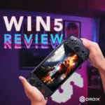 Elav pisipilt GPD WIN 5 pihuarvuti mängukonsooli videoülevaate jaoks. Kätepaar hoiab musta konsooli, mis on veidi vaataja poole kaldu. Ekraanil kuvatakse intensiivne võidusõidumängu stseen helendava autoga. Taustaks on eredalt valgustatud ruum, kus on lillad ja neoonaktsendid. Suur valge tekst, mille vasakule küljele on asetatud roosa ja sinise glitchi sarnane efekt: "WIN 5 REVIEW". DROIXi logo on paremas alumises nurgas.     