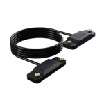 ONEXPLAYER-APEX-BATTERY-CABLE-LISTING-DONE-01 - DROIX EU An image of the ONEXPLAYER APEX Battery Interface cable. The product consists of a long, coiled black cable connecting two identical, rectangular black plastic blocks. Each block features the "APEX battery interface" logo embossed on the top surface and is equipped with two small, gold-colored knurled thumbscrews at the ends for secure attachment. The entire assembly is displayed against a solid black background.