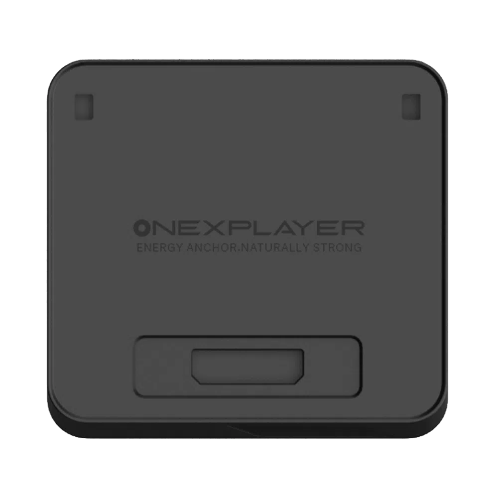 A top-down view of the ONEXPLAYER APEX Battery Dock, a square-shaped, matte black electronic accessory with rounded corners. The center of the device features the embossed ONEXPLAYER logo, followed by the slogan "ENERGY ANCHOR, NATURALLY STRONG". There are two small rectangular indentations near the top corners and a larger, recessed rectangular port or connection area located at the bottom center of the face.
