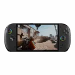 A sleek, black handheld gaming console, the ONEXPLAYER, is shown from a direct front-facing view against a solid white background. Key Visual Details: Screen: A large, vibrant display fills the center, showing a third-person shooter video game set in a dusty, industrial desert environment. A character in an orange suit is visible in the foreground. Controls: * Left Side: Features a circular joystick with a multi-colored RGB LED ring and a classic cross-shaped D-pad. Right Side: Features four action buttons (labeled X, Y, A, B), a second joystick with a matching RGB ring, and a dedicated "ONEX" button near the bottom. Design: The device has a rounded, ergonomic "pill" shape with a matte black finish. The "ONEXPLAYER" branding is subtly printed centered just below the screen.