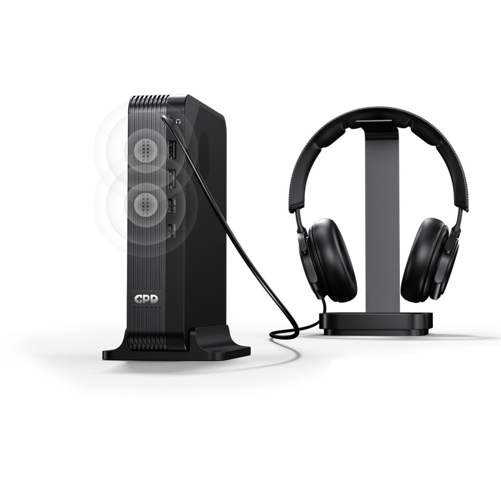 GPD BOX Mini PC 5 A marketing image showing the GPD device vertically docked. A cable connects its top audio jack to a pair of black over-ear headphones sitting on a stand. Faint white concentric circles emanate from the front of the unit, illustrating the built-in speaker functionality alongside the wired audio output.