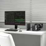 Front angled view of matte black GPD BOX GPD Mini PC with PCIe eGPU, triple-fan GPU and code monitor on white desk
